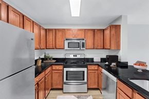 Laurel apartment for rent - a kitchen with wooden cabinets and stainless steel appliances