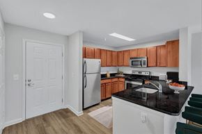 Laurel apartment for rent - a kitchen with white appliances and wooden cabinets