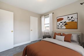 Hyattsville apartment for rent - A bedroom with a large bed and a painting on the wall.