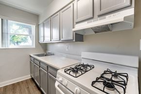 Hyattsville apartment for rent - A kitchen with a white stove top oven and white cabinets.
