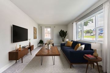 Hyattsville apartment for rent - A living room with a blue couch and a television on the wall.