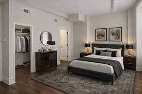 Richmond apartment for rent - A bedroom with a large bed, a dressing area, and a rug on the floor.