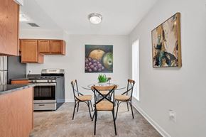 Manassas apartment for rent - a dining area with a table and chairs and a kitchen in the background