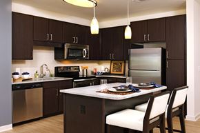 Mclean apartment for rent - a kitchen with stainless steel appliances and a island with chairs