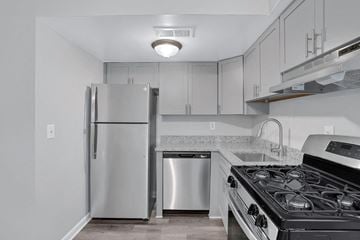 Chesapeake townhouse for rent - A kitchen with a stainless steel refrigerator, a dishwasher, and a stove top oven.