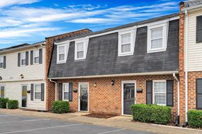 Chesapeake townhouse for rent - a brick apartment building with white siding and a black roof