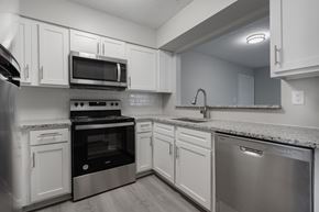 Portsmouth apartment for rent - A modern kitchen with stainless steel appliances and white cabinets.