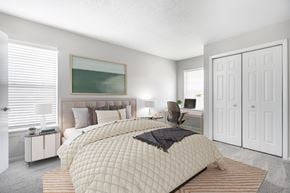Newport News apartment for rent - A bedroom with a large bed and a painting on the wall.