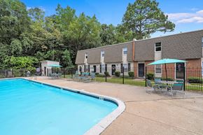 Hopewell townhouse for rent - A swimming pool surrounded by chairs and trees.