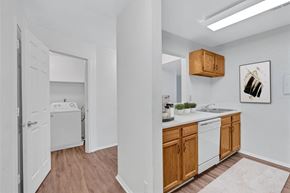 Charlottesville apartment for rent - A kitchen with white appliances and wooden cabinets.