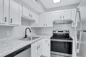 Newport News apartment for rent - a kitchen with white cabinets and black appliances