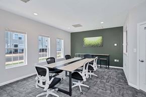 Lexington Park townhouse for rent - a conference room with a table and chairs and a tv on the wall