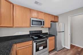 Winchester apartment for rent - A kitchen with wooden cabinets and a black countertop.