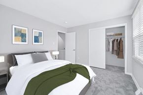 Richmond townhouse for rent - a bedroom with gray walls and a white bed with a green blanket