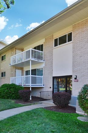 Falls Church apartment for rent - an exterior view of a brick building with a balcony and a sidewalk