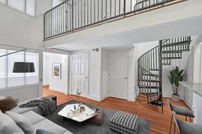 Richmond apartment for rent - a living room with a staircase in the background and a couch and a table
