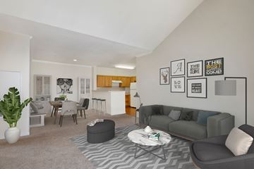 Largo apartment for rent - A living room with a grey couch, a coffee table, and a dining table with chairs.