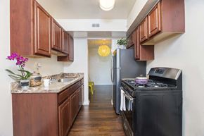 Hyattsville apartment for rent - a kitchen with black appliances and wooden cabinets