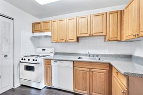 Oxon Hill apartment for rent - a kitchen with white appliances and wooden cabinets