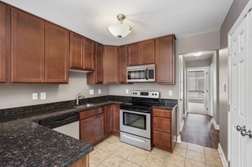 Frederick apartment for rent - a kitchen with granite counter tops and wooden cabinets