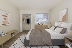 Landover Hills apartment for rent - A bedroom with a large bed and a window overlooking a building.