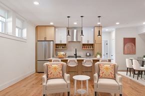 Richmond apartment for rent - A kitchen with a refrigerator, a sink, and a dining table with chairs.