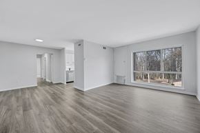Reston apartment for rent - A spacious room with wooden flooring and a large window.