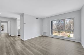 Reston apartment for rent - A room with a large window and a view of trees outside.