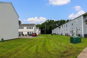 Chesapeake townhouse for rent - a row of houses on a grassy lot with a blue sky in the background