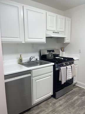 Arlington apartment for rent - A kitchen with white cabinets and a black stove top oven.