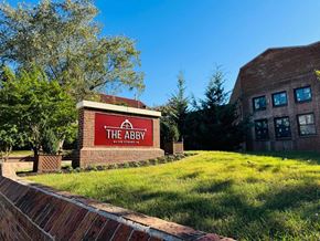 Richmond apartment for rent - a brick building with a sign for the abbey on a lawn