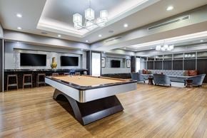 Mclean apartment for rent - A pool table is in the middle of a room with a bar and a couch.