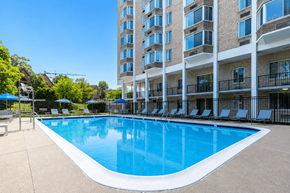 Alexandria apartment for rent - A large swimming pool in front of a multi-story apartment building.