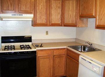 College Park apartment for rent - A kitchen with wooden cabinets and a black stove top oven.