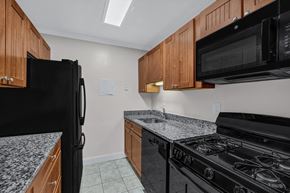 Bethesda apartment for rent - A kitchen with black appliances and wooden cabinets.