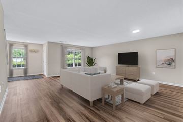 Fredericksburg townhouse for rent - A living room with a white couch and a television on the wall.