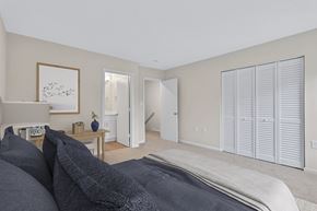 Fredericksburg townhouse for rent - A bedroom with a large bed and a painting on the wall.