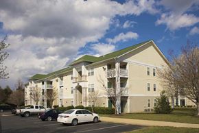 Lexington Park apartment for rent - a large apartment building with cars parked in a parking lot