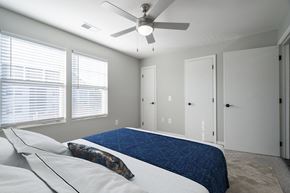 Lexington Park apartment for rent - A bedroom with a bed, pillows, and a ceiling fan.