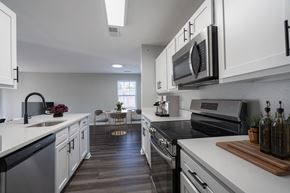 Lexington Park apartment for rent - A modern kitchen with white cabinets and black appliances.