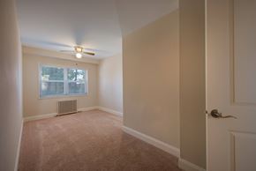 Springfield apartment for rent - A room with a carpeted floor, a ceiling fan, and a window with blinds.