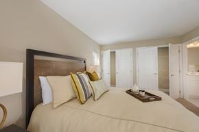 Winchester apartment for rent - A bedroom with a large bed and a tray of cream colored flowers on the bed.