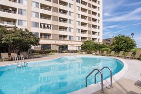 Laurel apartment for rent - A large swimming pool in front of a multi-story apartment building.