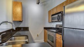 Richmond apartment for rent - a kitchen with stainless steel appliances and wooden cabinets