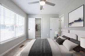 Great Mills apartment for rent - A bedroom with a large bed and a ceiling fan.