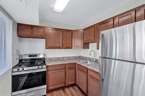 Alexandria apartment for rent - A kitchen with brown cabinets and a stainless steel refrigerator.