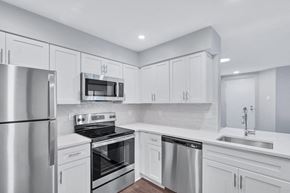 Reston apartment for rent - Immaculate kitchen featuring sleek stainless steel appliances and pristine white cabinets.