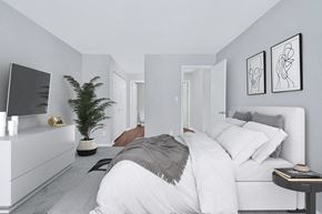 Reston apartment for rent - A sophisticated bedroom displaying a pristine white bed and a contemporary television.