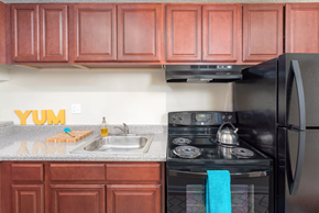 Richmond apartment for rent - a kitchen with black appliances and wooden cabinets