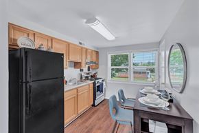 Catonsville apartment for rent - a kitchen with a black refrigerator and a table and chairs